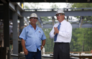 Bill Hannah, CEO of Nabholz Construction Corp. of Conway, right, talks to an employee at a job site.