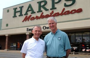 Harp's Food Stores President Kim Eskew, left, and CEO Roger Collins stand in front of a store in Springdale.