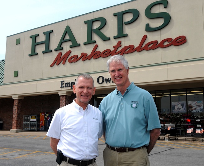 Harp's Food Stores President Kim Eskew, left, and CEO Roger Collins stand in front of a store in Springdale.