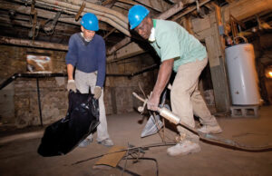 Chuck Wilks, left, and Darryl Ellis work at a Snyder Environmental job on Main Street in Little Rock. Snyder is offering Our House clients like Wilks and Ellis stipends so they can pursue asbestos training.&nbsp;