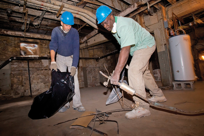 Chuck Wilks, left, and Darryl Ellis work at a Snyder Environmental job on Main Street in Little Rock. Snyder is offering Our House clients like Wilks and Ellis stipends so they can pursue asbestos training.&nbsp;