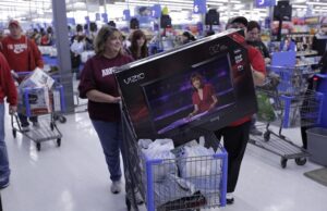 Shoppers at a Wal-Mart in Bentonville snatch up flat-screen televisions during Black Friday 2011.