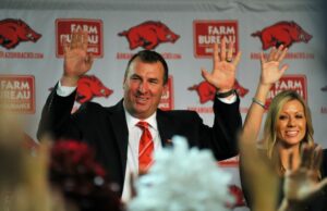 New University of Arkansas football coach Bret Bielema leads a Hog Call at his introductory press conference. He was joined on stage by his wife, Jen.
