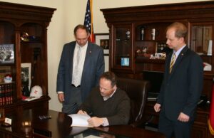 With Gov. Mike Beebe out of the state, Lt. Gov. Mark Darr signed into law a bill that would make secret the names of concealed carry permit holders as bill sponsors Sen. Bruce Holland (left), R-Greenwood, and Rep. Andy Davis, R-Little Rock, looked on. Beebe on Tuesday criticized Darr for signing the bill in his absence. (Submitted photo)