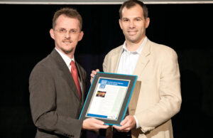 James Sheppard, assistant director of client services for Rockfish of Rogers, accepts a 2013 Best Places to Work award from Arkansas Business Publisher Mitch Bettis.