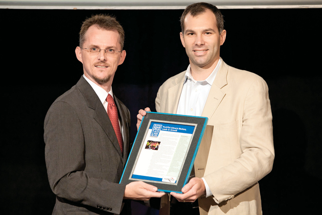 James Sheppard, assistant director of client services for Rockfish of Rogers, accepts a 2013 Best Places to Work award from Arkansas Business Publisher Mitch Bettis.