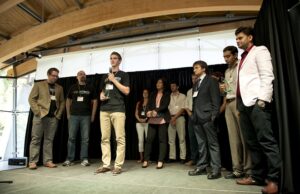 Josh Moody (center), a senior at Catholic High, with Overwatch team members Joe Saumweber and Michael Paladino (at left), thanks the crowd at the 2013 ARK Challenge Demo Day after Overwatch was named one of three winners.