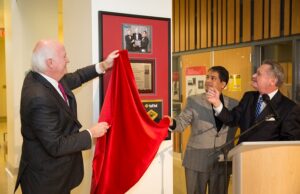 NanoMech CEO Jim Phillips, NanoMech founder Ajay Malshe and UA Chancellor David Gearhart unveil a plaque recognizing the company&rsquo;s R&D 100 award in 2013.