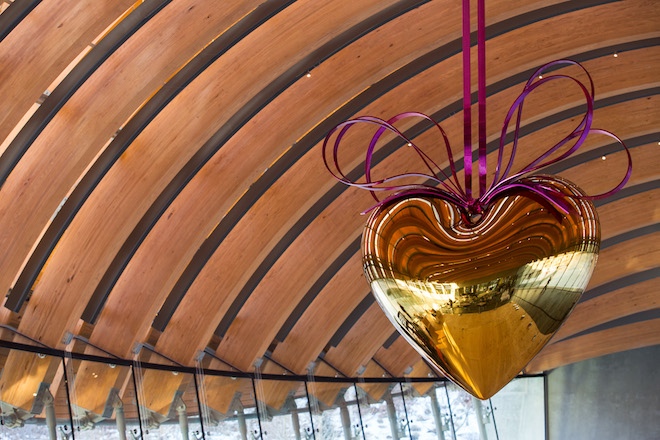 Jeff Koons' Hanging Heart (Gold/Magenta) is now suspended from the ribbed ceiling of one of the Crystal Bridges' glass-walled bridges.