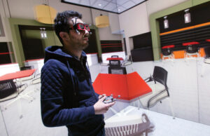 Grad student Mohamed Messaoudi enters a virtual world as he interacts with the EmergiFLEX 3-D data visualization equipment at the University of Arkansas at Little Rock&rsquo;s Emerging Analytics Center. (Photo by Russell Powell)