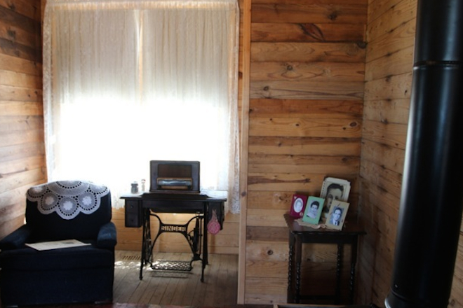 An old Singer sewing machine and an AM radio sit in the living room at House #266.
