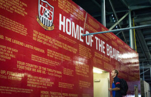 U.S. Men's Soccer coach J&uuml;rgen Klinsmann looks at a wall of supporting quotes outside the team's locker room. The wall of quotes was one of several design pieces completed by Stone Ward, an advertising agency headquartered in Little Rock, which represents the U.S. Soccer Federation.