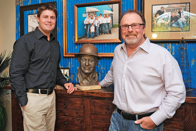 Grant, left, and his father, Alan Pruitt, right, pose with a sculpture of A.B. &ldquo;Buddy&rdquo; Pruitt, the founder of Pruitt Tool & Supply Co. | (Photo by Ryan Miller)