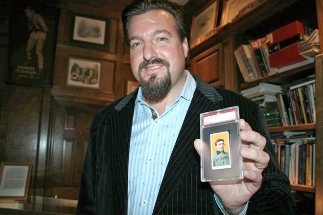 John Rogers holds a valuable 1909 Honus Wagner baseball card after its 2008 purchase. |