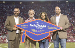 Nabil Tovar (center), an Academic Challenge Scholarship recipient who attends the University of Arkansas, participated in an on-field Arkansas Scholarship Lottery presentation with (from left to right) Daniel Pugh, vice provost for student affairs, Thomas Smith, dean of College of Education and Health Professions and Bishop Woosley, director of the Arkansas Scholarship Lottery during a football game at UA on Sept. 20. | (Photo courtesy of Arkansas Scholarship Lottery)