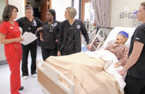 Ginger Covington (far left), SAU simulation coordinator and instructor of nursing, works with students in a simulation lab at Wharton Nursing Building.