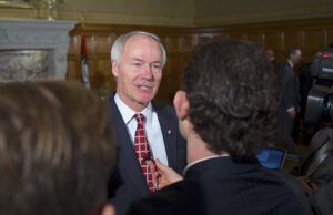 Asa Hutchinson spent much of a news conference announcing the new economic development leader explaining his position on HB1228.