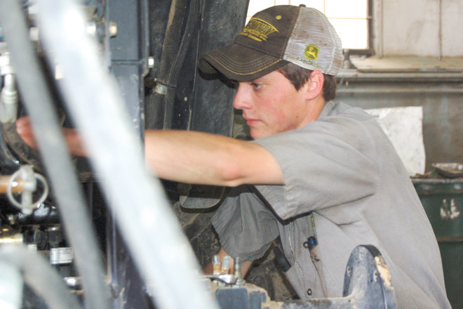 Ethan Patterson works on a tractor at the Greenway facility in Brinkley. Patterson, a Greenway employee, graduated the ASU-Beebe ag equipment technician program.