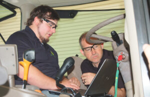 Shawn Tallion (right) helps Tanner Coldiron diagnose a tractor issue at the John Deere technician facility at Arkansas State-Beebe.