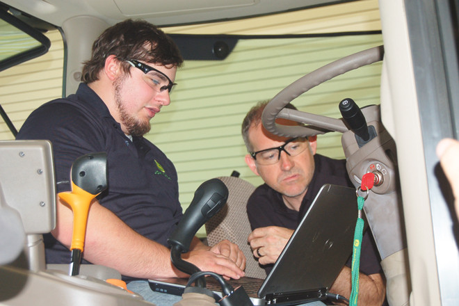Shawn Tallion (right) helps Tanner Coldiron diagnose a tractor issue at the John Deere technician facility at Arkansas State-Beebe.