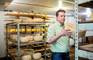 Kent Walker turns a wheel of cheese in the cheese cave. Walker used Kickstarter to raise extra money for his tasting room at Kent Walker Artisan Cheese.