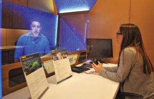 Tia Shilbley, assistant manager of United Federal Credit Union’s new Springdale branch, tests new 3D technology with Business Sales Strategy Manager Mark Dobberstein.