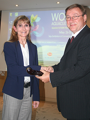 Dr. Rebecca Lochmann, incoming president of the World Aquaculture Society, is passed the gavel by Graham Mair, outgoing president, during the society&rsquo;s conference held in May in Jeju, South Korea.