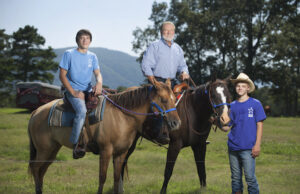 Larry Stone with kids who live on one of the Arkansas Sheriffs' Youth Ranches, where they have responsiblities like taking care of the animals and helping with normal household chores in the homes where they live with foster parents.