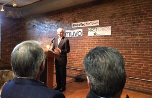 Gov. Asa Hutchinson speaks at the press conference announcing the official opening of tech firms Inuvo and First Orion/PrivacyStar in the River Market District's Museum Building, as PrivacyStar's Charles Morgan and Inuvo's Richard Howe look on.