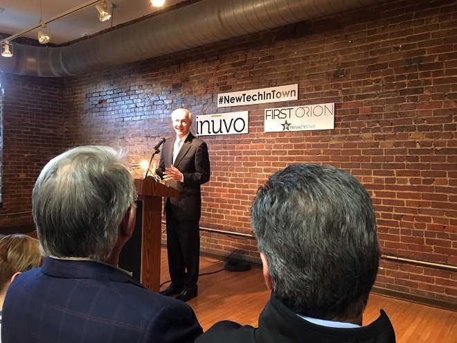 Gov. Asa Hutchinson speaks at the press conference announcing the official opening of tech firms Inuvo and First Orion/PrivacyStar in the River Market District's Museum Building, as PrivacyStar's Charles Morgan and Inuvo's Richard Howe look on.