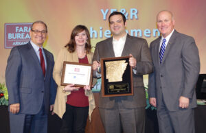 Arkansas Farm Bureau president Randy Veach (left) presents the 2015 Young Farmers and Ranchers Achievement Award to Shannon and Derek Haigwood of Newport with vice president Rich Hillman.