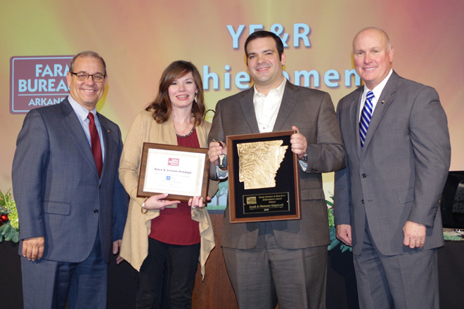 Arkansas Farm Bureau president Randy Veach (left) presents the 2015 Young Farmers and Ranchers Achievement Award to Shannon and Derek Haigwood of Newport with vice president Rich Hillman.
