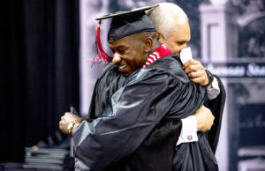 Arkansas State University Athletic Director Terry Mohajir hugging Charleston Girley, an A-State football player who benefited from the Red Wolves Leadership Academy.