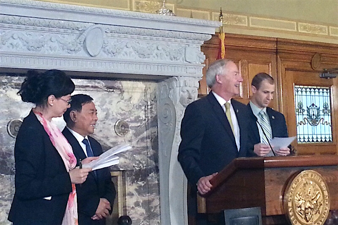 Gov. Asa Hutchinson introduces Sun Paper Chairman Hongxin Li at a news conference April 26.
