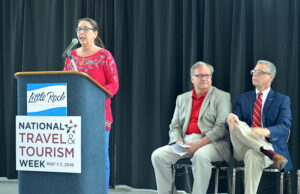 (From left) Capi Peck, chair of the Little Rock Advertising and Promotion Commission, speaks at the "Travel '16'" event Tuesday as John Mayner, vice president of marketing and communications for the Little Rock Convention Center and Kane Webb, executive director of the Arkansas Department of Parks & Tourism, look on.