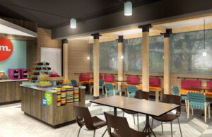 One of the four sections of a Tru by Hilton hotel lobby, featuring multiple seating options and a buffet bar.