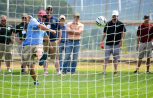 At Turfgrass Field Day in 2014, attendees take turns trying to kick a goal with a soccer ball fitted with an instrument to measure kicking force.