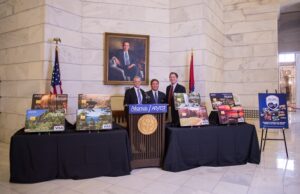 Kane Webb, director of the Arkansas Department of Parks & Tourism; Jim Cargill, president and incoming CEO of Arvest Central Arkansas; and Joe David Rice, tourism director for the department, unveil eight speciality debit cards featuring images of some of the state's most well known attractions.&nbsp;