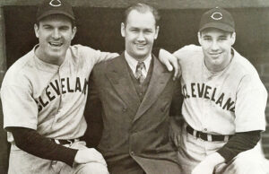 Legendary baseball photographer George Brace poses with outfielder Jeff Heath, left, and future Hall of Famer Bob Feller of the Cleveland Indians.