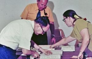 Director of Broadcasting Charles Rasberry, KASU Chief Engineer Roy Barnhill (with pipe) and A-State journalism instructor Rebecca Gardner working on Corporation for Public Broadcasting grant papers in 1975.