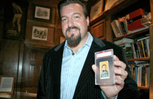 John Rogers proudly displays a rare Honus Wagner baseball card during a party at his home on Dec. 12, 2008.  The holiday soiree celebrated his purchase of the valuable card, which he owned for six months. He bought it for a reported $1.6 million but sold it later for $1 million + $1.