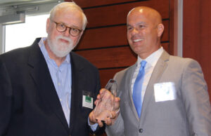 North Little Rock Officer Tommy Norman accepts the IABC Arkansas award for Communicator of the Year from Neal Moore.