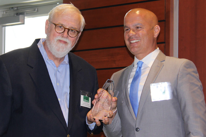 North Little Rock Officer Tommy Norman accepts the IABC Arkansas award for Communicator of the Year from Neal Moore.