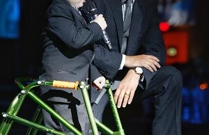 Evan Lee, this year's Will Golf 4 Kids Tournament champion, speaks at the Color of Hope Gala with gala Co-Chair Charles Redfield.