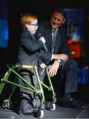 Evan Lee, this year's Will Golf 4 Kids Tournament champion, speaks at the Color of Hope Gala with gala Co-Chair Charles Redfield.