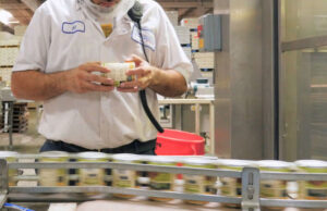 An employee of Simmons Foods monitors cans for inspection.