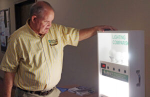 Mark Cayce, Ouachita Electric’s CEO, shows off a display on the benefits of efficient lighting, a key part of the co-op’s PAYS program.