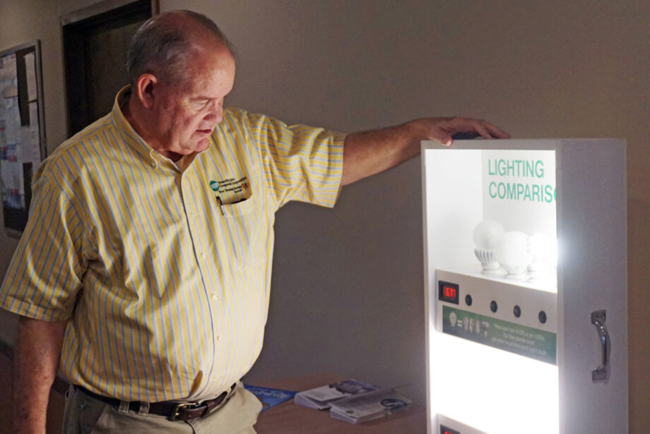 Mark Cayce, Ouachita Electric’s CEO, shows off a display on the benefits of efficient lighting, a key part of the co-op’s PAYS program.