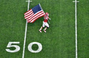 Arkansas Razorback Grant Cook carries an American flag on to the field at War Memorial Stadium on Sept. 11, 2011.
