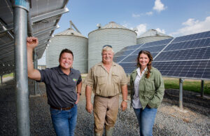 Seal Energy Solutions CEO Josh Davenport and President and COO Heather Nelson flank DeWitt farmer Tom Jacobs. Seal installed a solar array to help power Jacobs’ farm operations.